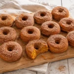 Baked Pumpkin Donuts with a soft orange crumb and cinnamon-sugar coating arranged on a neutral serving plate.